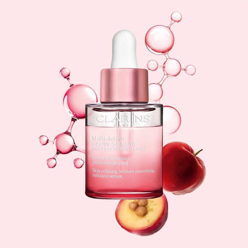 Plan produit de Multi-Active Glow Serum avec molécule de vitamine C et acérola sur fond rose clair, ravivant l’éclat de la peau.